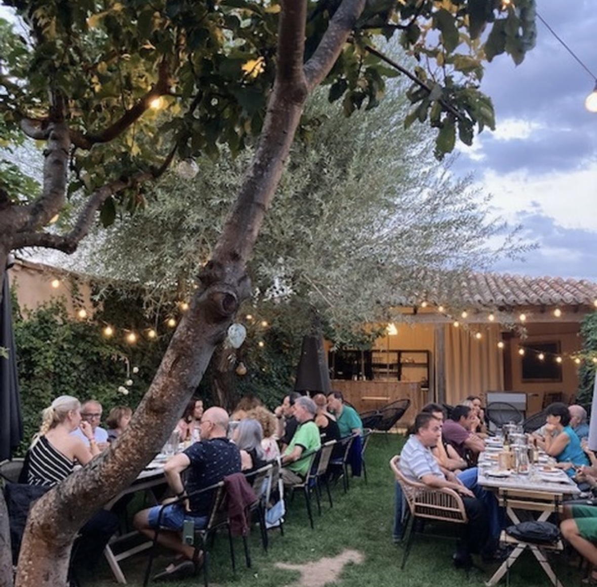 Comensales disfrutan de una de las citas gastronómicas en el jardín de Entretierras.